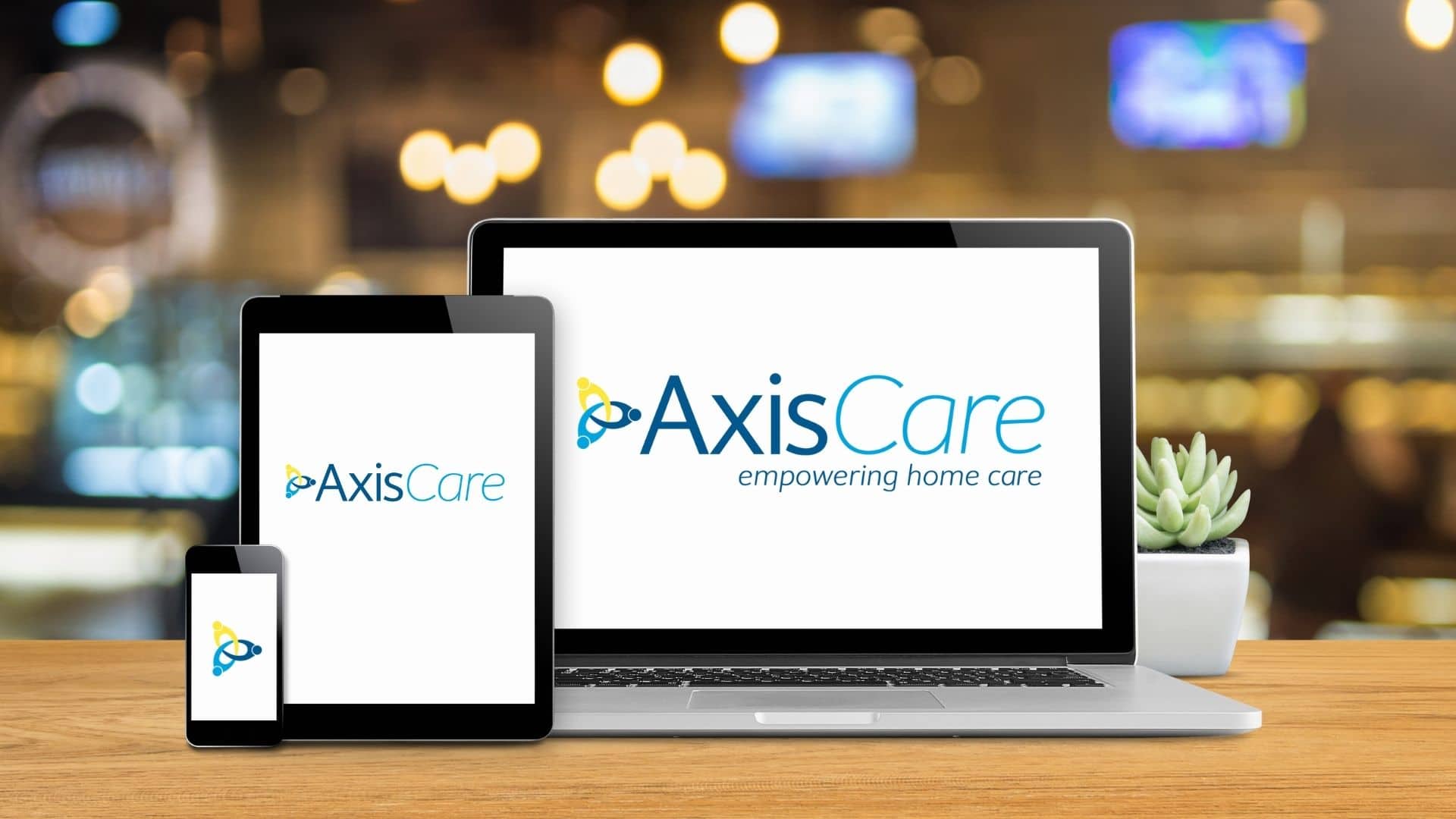 AxisCare home care software logo displayed on laptop, iPad and phone