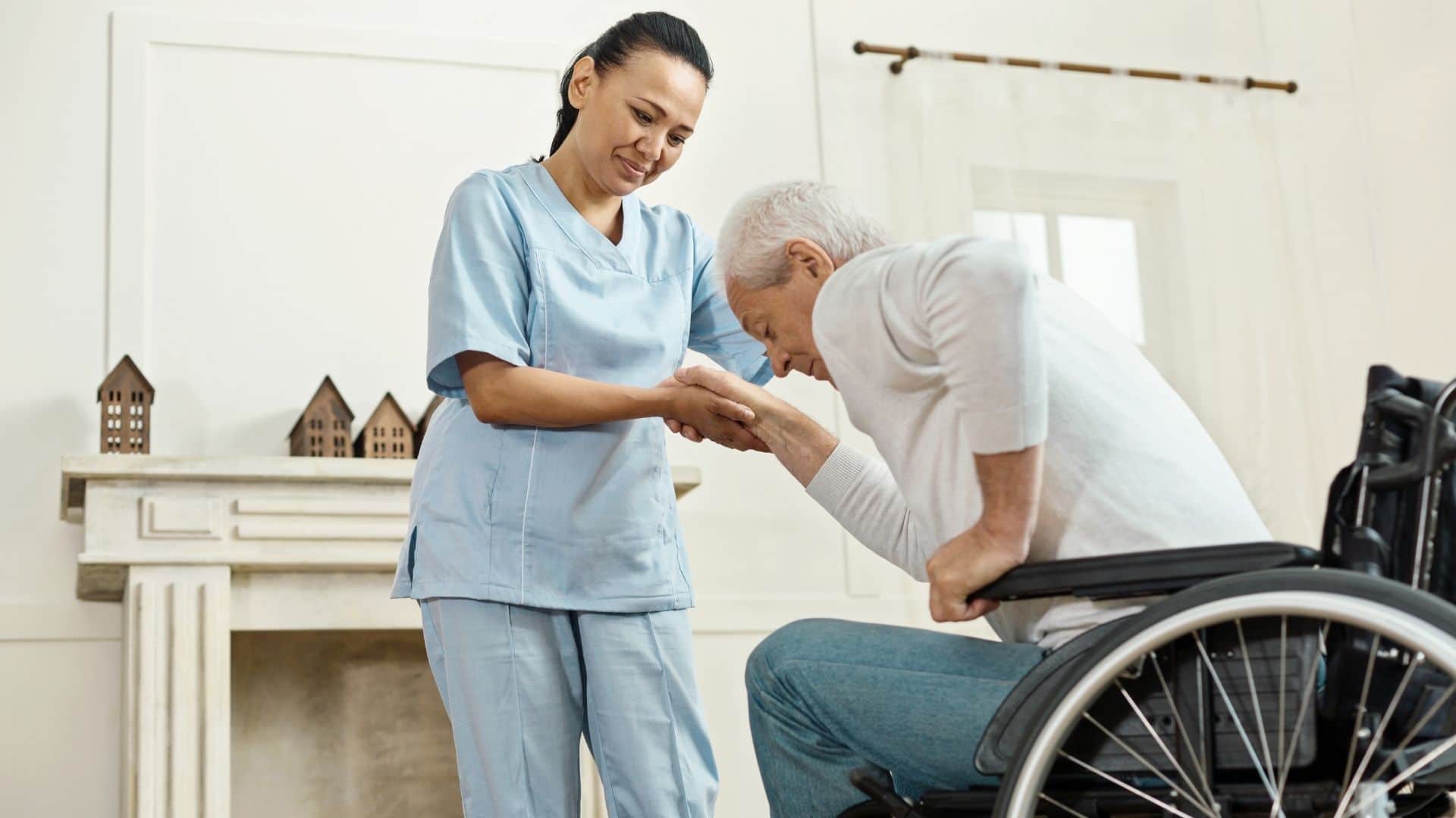 Happy caregiver assisting client as he stands from wheelchair