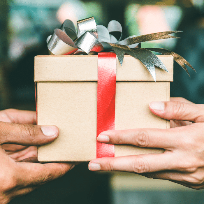 Two people's hands giving and receiving a gift