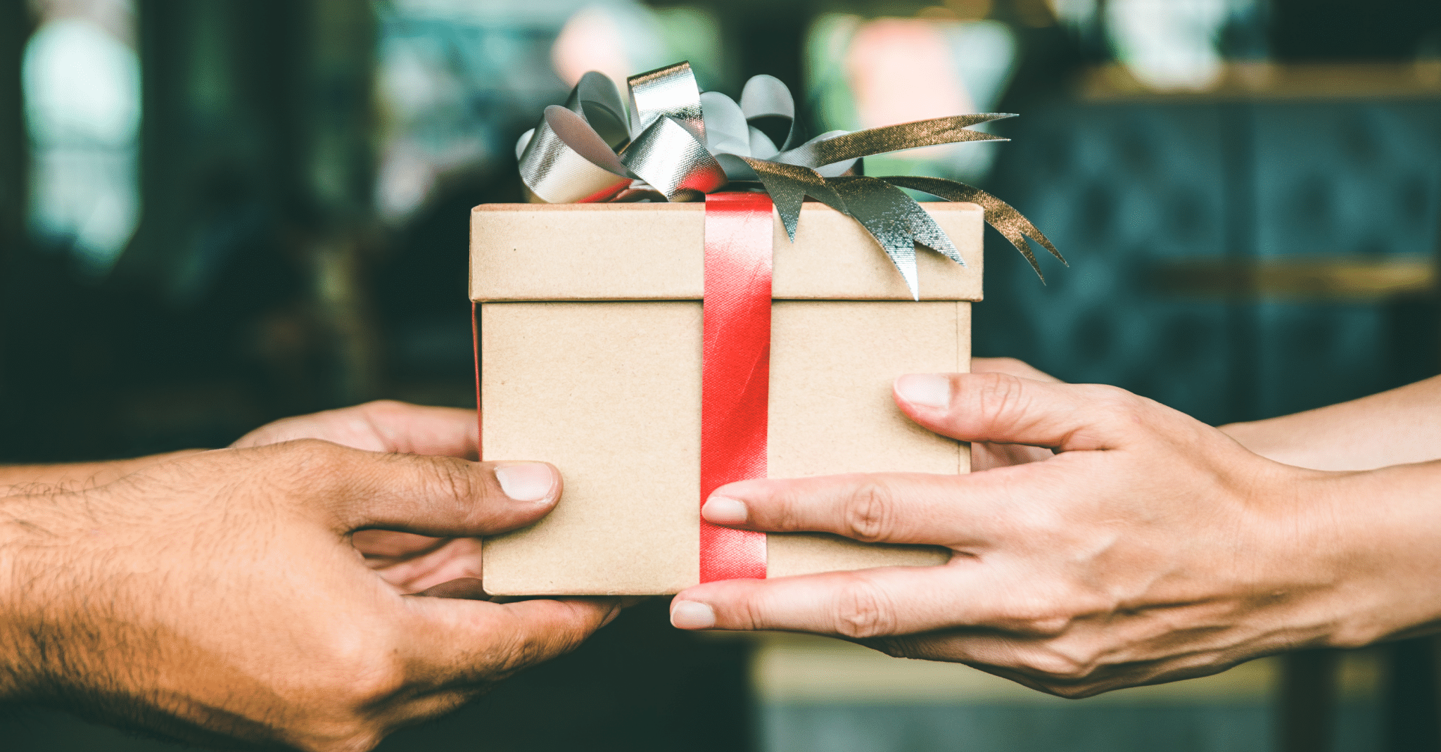 Two people's hands giving and receiving a gift