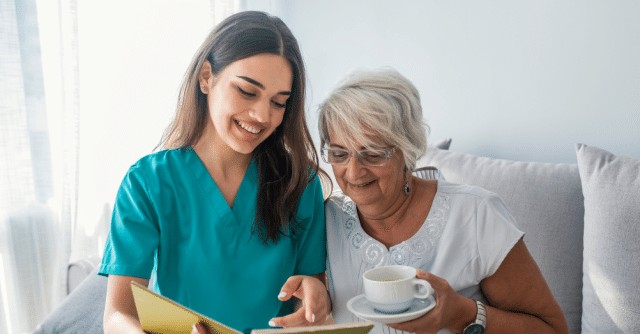 A caregiver and elderly person looking at something together