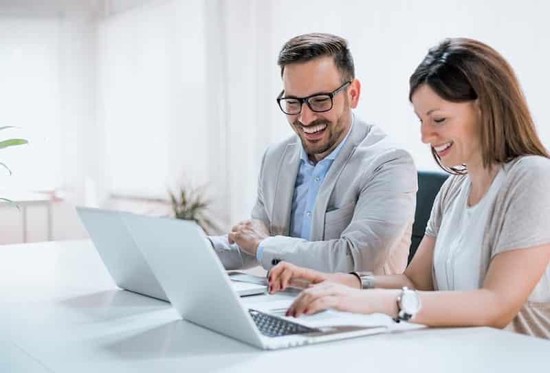 man and woman working on laptops