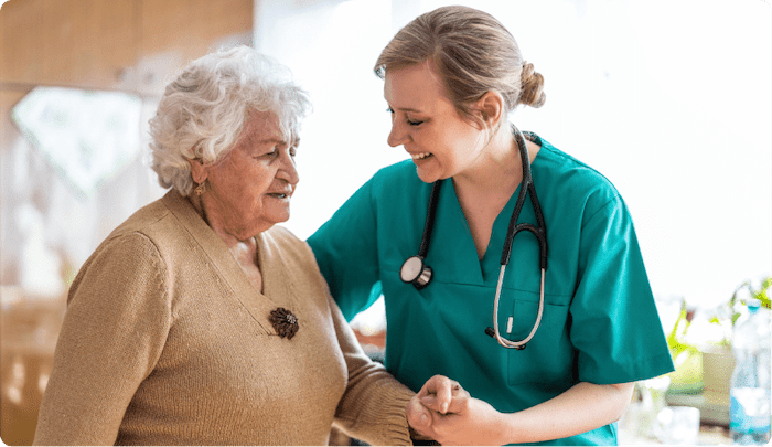 caregiver helping older female patient