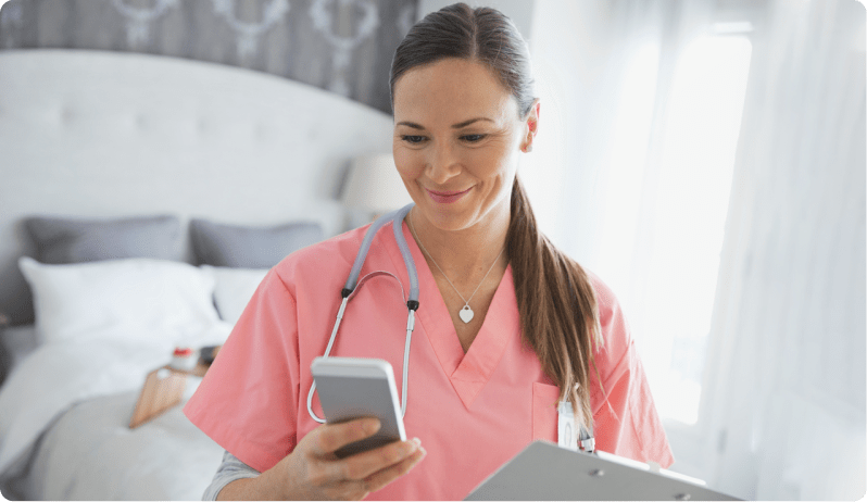 female caregiver smiling and looking at phone
