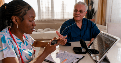 caregiver taking elderly man's vitals