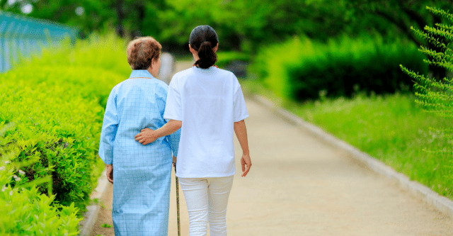 caregiver walking with an elderly woman