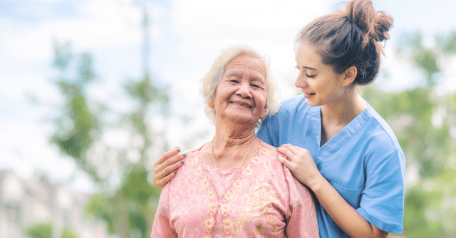 a caregiver standing behind an elderly woman