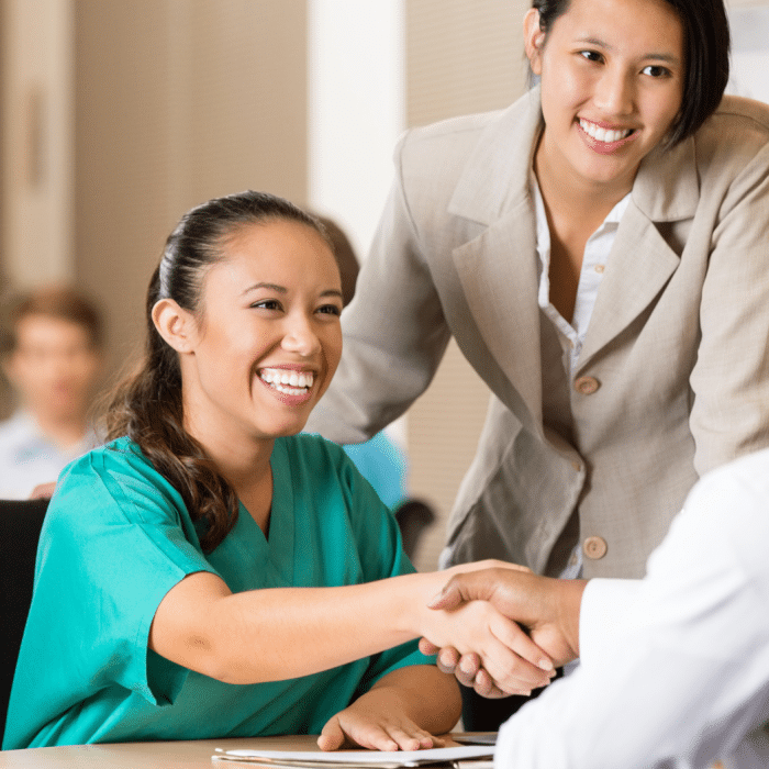 A caregiver shaking her manager's hand in a work environment