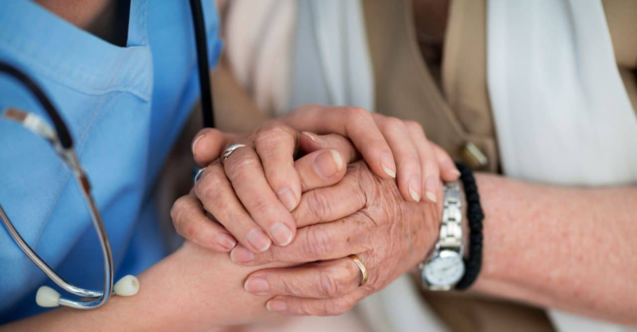 caregiver and client holding hands