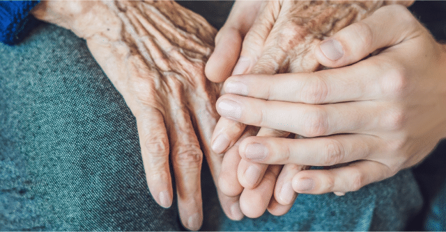 Zoom in on Caregiver hand holding onto patient's hand