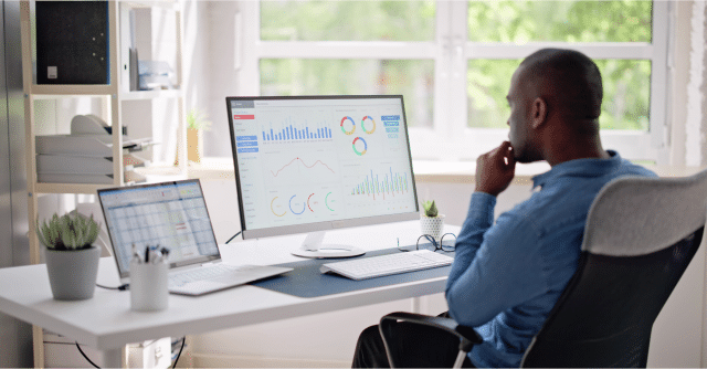 man on computer looking at spreadsheets