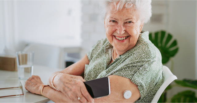 elderly woman using remote patient monitoring device at home