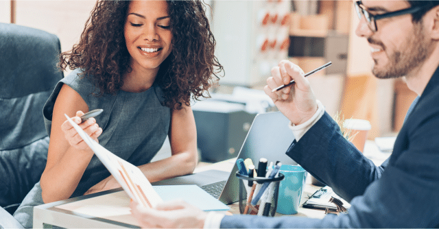 woman and business man looking over spreadsheet