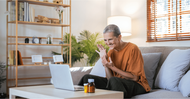 Older woman sitting with laptop on couch