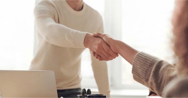 person shaking hand of their new boss after being hired