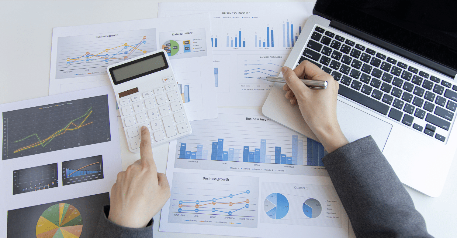 mans hands and spreadsheets with calculator and computer