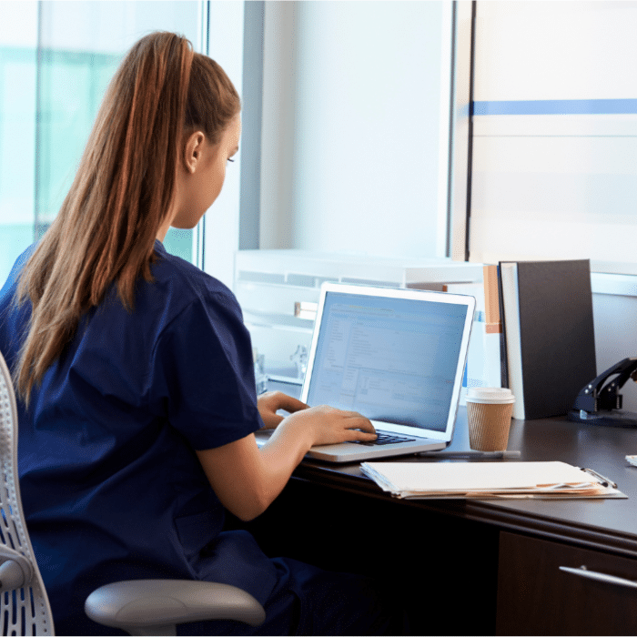 woman typing caregiver notes on computer